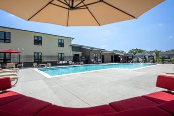 Resort-style lap pool with large sundeck featuring lounge seating and ample shade