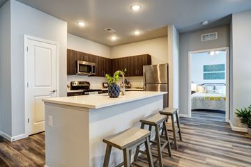 Louisville apartment for rent - A kitchen with a white counter top and wooden floors.