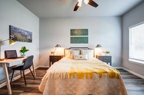 Louisville apartment for rent - A bedroom with a bed, desk, and chair.