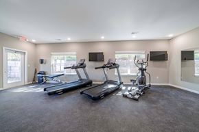 Louisville apartment for rent - A spacious room with a treadmill, elliptical trainer, and stationary bike.