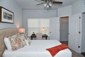 Louisville apartment for rent - a bedroom with a large white bed and a ceiling fan