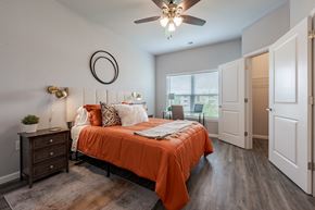 New Albany apartment for rent - a bedroom with an orange bed and a ceiling fan