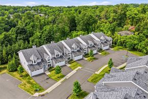 Mountainside apartment for rent - A bird's eye view of a residential area with houses and trees.