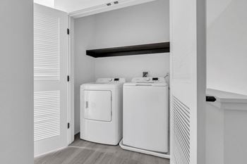A laundry room with two washers and a dryer in it