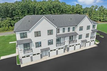 An aerial view of a white building with a gray roof