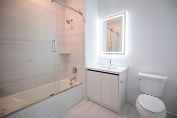 A white bathroom with a shower toilet and sink