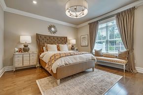Mountainside apartment for rent - A bedroom with a large bed and a bench by the window.