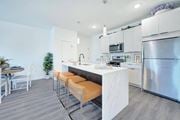 Hillsborough Township apartment for rent - a kitchen with stainless steel appliances and a bar with orange stools at The Franklin at Hillsborough Apartments, New Jersey, 08844