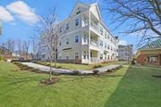 Hillsborough Township apartment for rent - a large apartment building with a lawn and sidewalk in front of it at The Franklin at Hillsborough Apartments, Hillsborough, NJ 08844