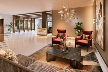 Tenafly apartment for rent - A modern living room with a black coffee table and red chairs.