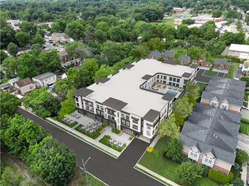 Tenafly apartment for rent - An aerial view of a modern building surrounded by trees and other buildings.