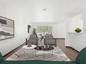 Pensacola apartment for rent - A living room with a black and white rug and two grey chairs.