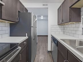 Pensacola apartment for rent - a kitchen with stainless steel appliances and wooden floors at The Overlook at Pensacola Bay, Pensacola