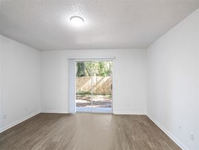 Pensacola apartment for rent - A room with a sliding glass door leading to a backyard. at The Palmiere Apartments, Pensacola, FL