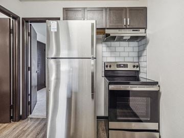 Pensacola apartment for rent - A modern kitchen with a stainless steel refrigerator and oven.