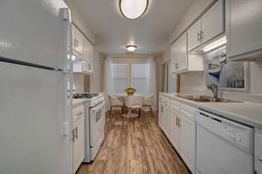 Fort Walton Beach apartment for rent - a large white kitchen with white cabinets and a wood floor at Estates at Palm Bay, Fort Walton Beach, 32547