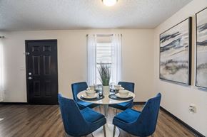 Pensacola apartment for rent - a dining room with a glass table and blue chairs at The Lorient Apartments, Pensacola, 32514