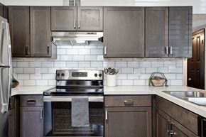 Pensacola apartment for rent - a kitchen with stainless steel appliances and wooden cabinets at The Lorient Apartments, Pensacola, FL 32514