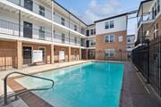 Metairie apartment for rent - the pool is in front of an apartment building with a pool at The Maxwell Apartments, Metairie Florida