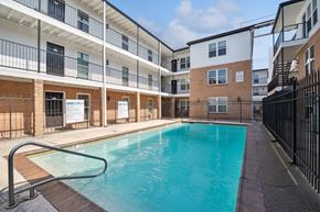 Metairie apartment for rent - the pool is in front of an apartment building with a pool at The Maxwell Apartments, Metairie Florida