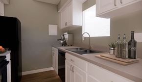 Fort Worth apartment for rent - A kitchen with white cabinets and a black refrigerator.