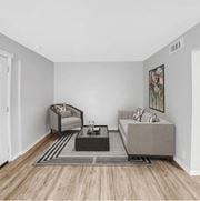 Metairie apartment for rent - A living room with a grey sofa, a grey armchair, a black coffee table and a grey rug.