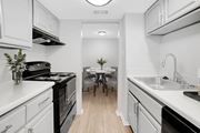 Metairie apartment for rent - A kitchen with white cabinets and black appliances.
