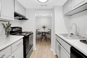Metairie apartment for rent - A kitchen with white cabinets and black appliances.