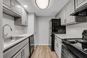 Metairie apartment for rent - A kitchen with a black refrigerator and stove top oven.