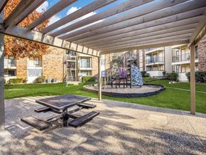 Dallas apartment for rent - an outdoor patio with a picnic table and a playground