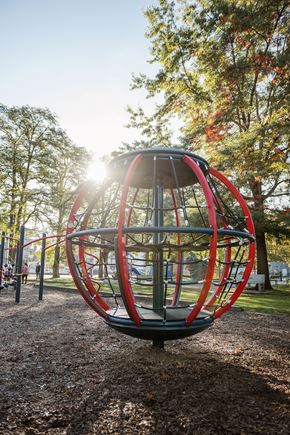 Langley apartment for rent - A red and grey spherical playground structure in the middle of a park.