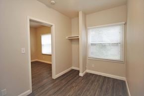 Oakland apartment for rent - a bedroom with a closet and a window and wood flooring