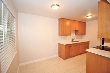 Oakland apartment for rent - a kitchen with wooden cabinets and a sink and a window