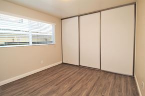 Oakland apartment for rent - a bedroom with white walls and wood flooring and a window