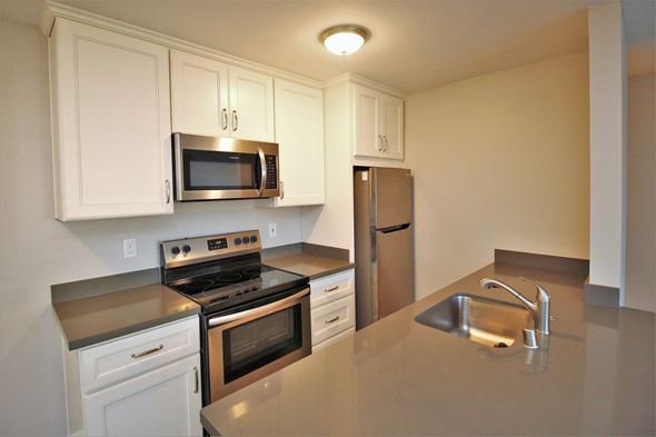 Oakland apartment for rent - a kitchen with stainless steel appliances and white cabinets
