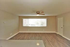 Oakland apartment for rent - an empty living room with a ceiling fan and a window