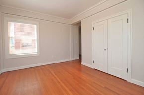 Oakland apartment for rent - a bedroom with white walls and wood floors and a window