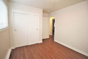Oakland apartment for rent - a bedroom with white walls and wood flooring and a closet