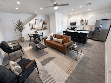 Tucson apartment for rent - A modern living room with a brown leather couch and a glass coffee table.