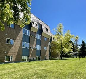 Bozeman apartment for rent - a brick apartment building with green grass and trees