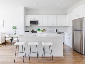 Plainfield apartment for rent - a kitchen with white cabinets and a large island with three stools