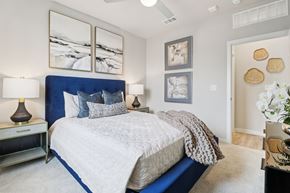 Corinth apartment for rent - A bedroom with a large bed and a painting on the wall.