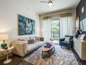 Dallas apartment for rent - A living room with a couch, a chair, a table, and a painting on the wall.