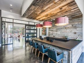 Dallas apartment for rent - A modern kitchen with a wooden ceiling and a long island with chairs.at Infinity on Yorktown, Dallas, TX