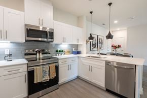 Burleson apartment for rent - A modern kitchen with white cabinets and stainless steel appliances.