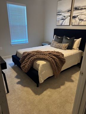 Corinth apartment for rent - A bedroom with a bed covered in a brown blanket and pillows at Arden at Corinth, Corinth, TX 76210