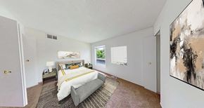 Grand Blanc apartment for rent - A bedroom with a large bed and a painting on the wall.