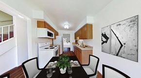 Grand Blanc apartment for rent - A black table with four chairs and a potted plant sits in a kitchen.