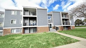 Kentwood apartment for rent - a view of an apartment building with a sidewalk and grass