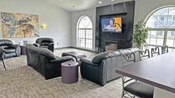 Howell apartment for rent - A living room with a television and black leather furniture.